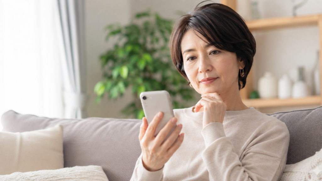 スマートフォンで結婚相談所の口コミを調べる40代女性