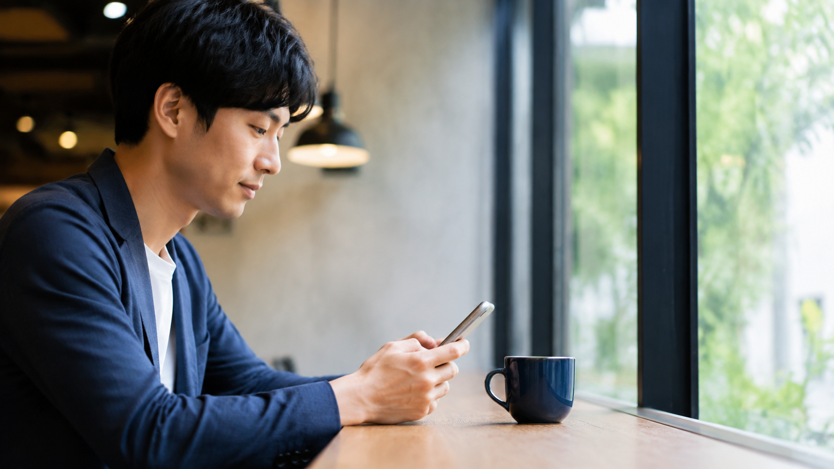 スマートフォンでニュース記事を読む20代から30代の人