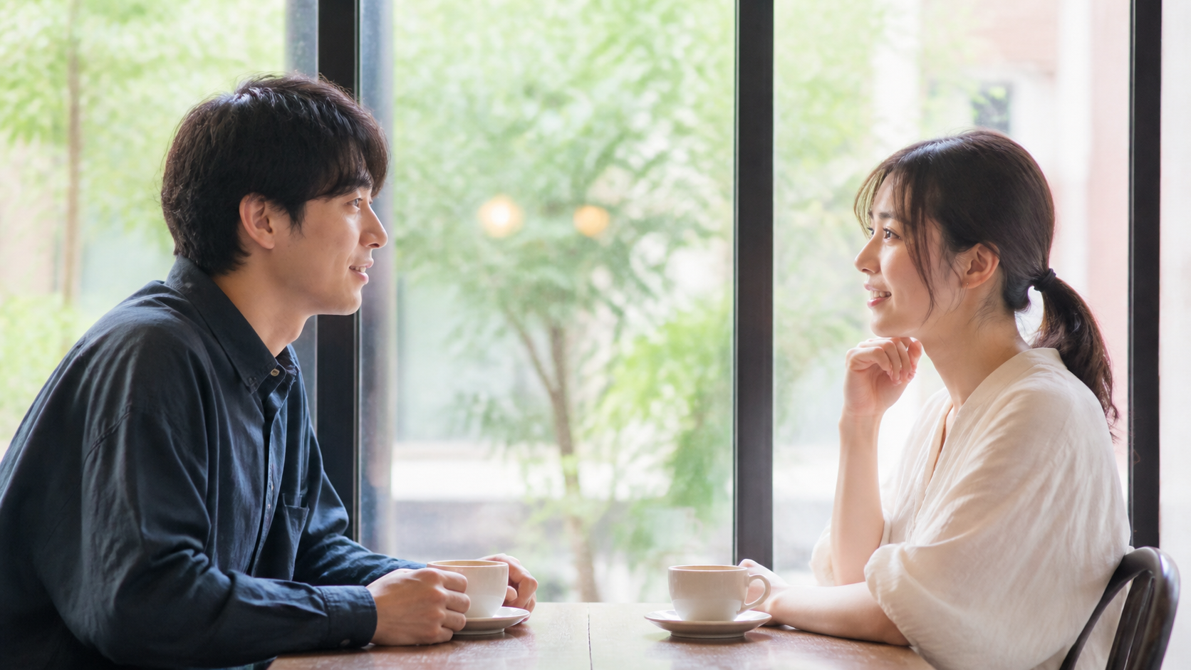 カフェで向かい合って穏やかに話す男女