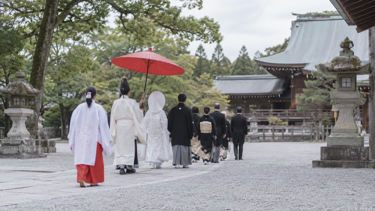 神社の境内を進む結婚式の参進の列