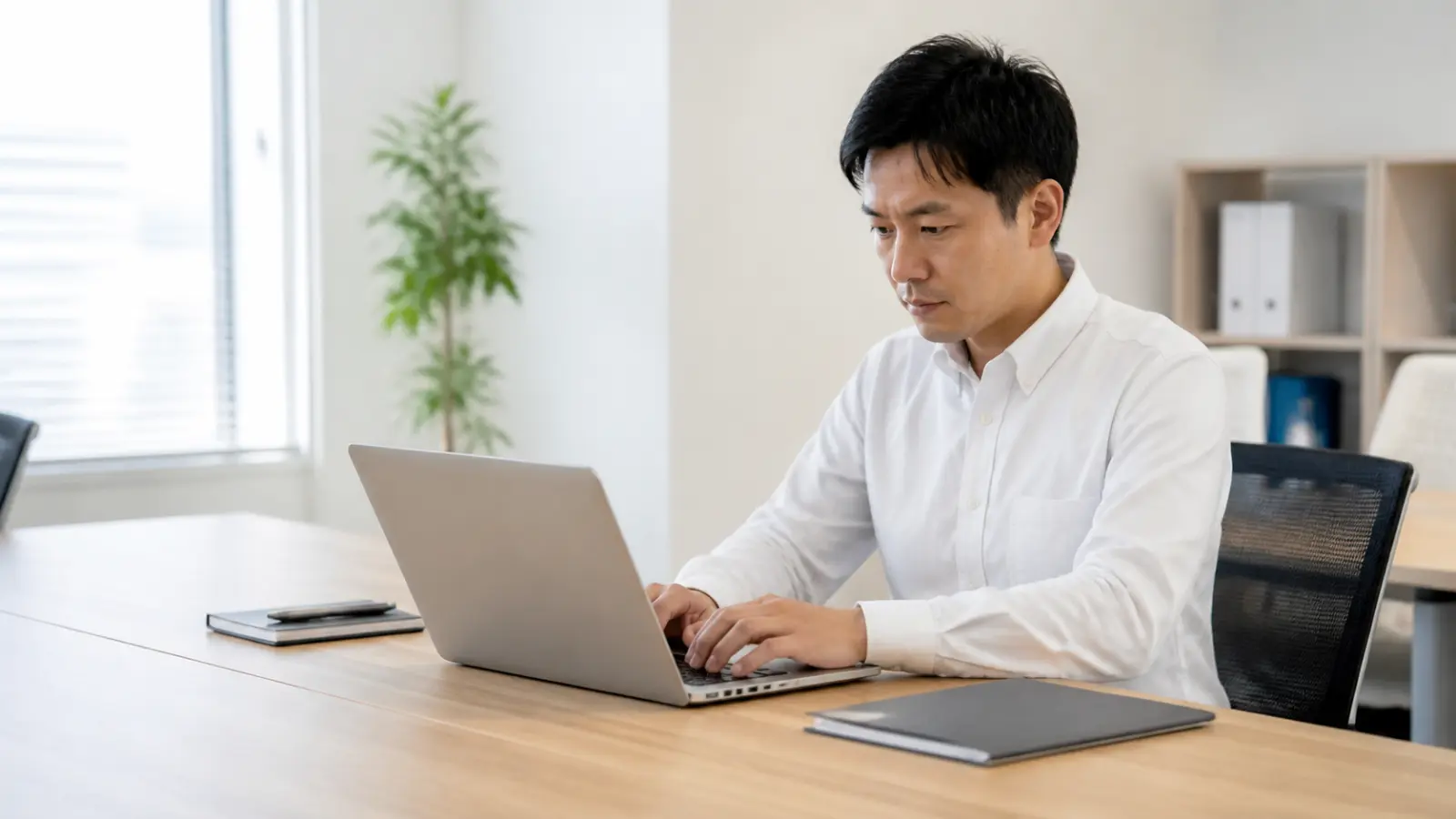 オフィスのデスクで働く30代から40代の会社員