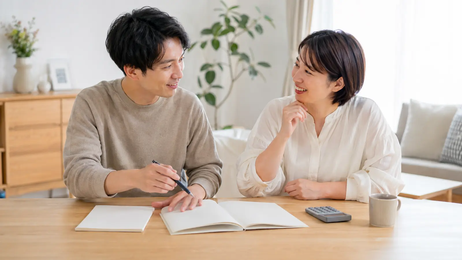 テーブルで家計について話し合う30代のカップル