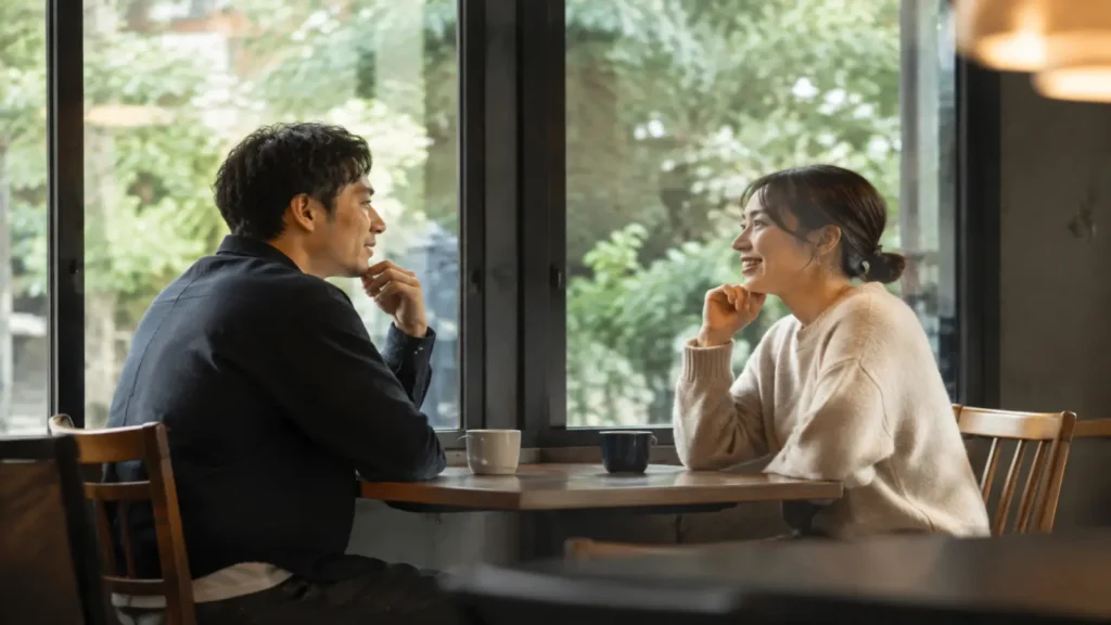 カフェで向かい合って話す2人のイメージ